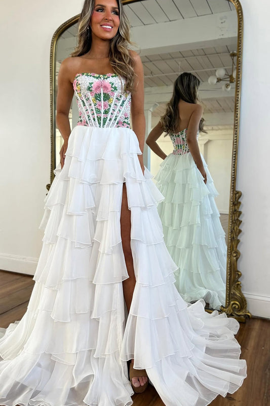 Une robe de bal en mousseline blanche, coupe trapèze, bustier et à volants