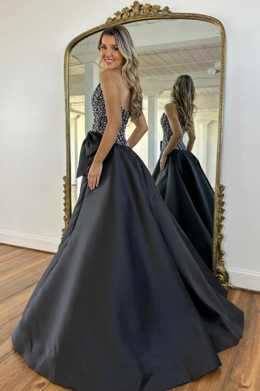 Une longue robe de bal bustier en satin noir coupe trapèze