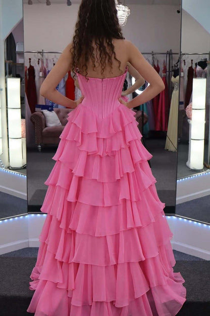 Robe de soirée longue en mousseline rose coupe trapèze sans bretelles à volants étagés