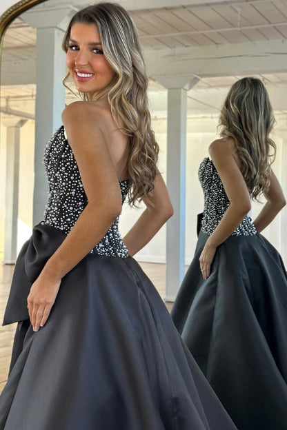 Une longue robe de bal bustier en satin noir coupe trapèze